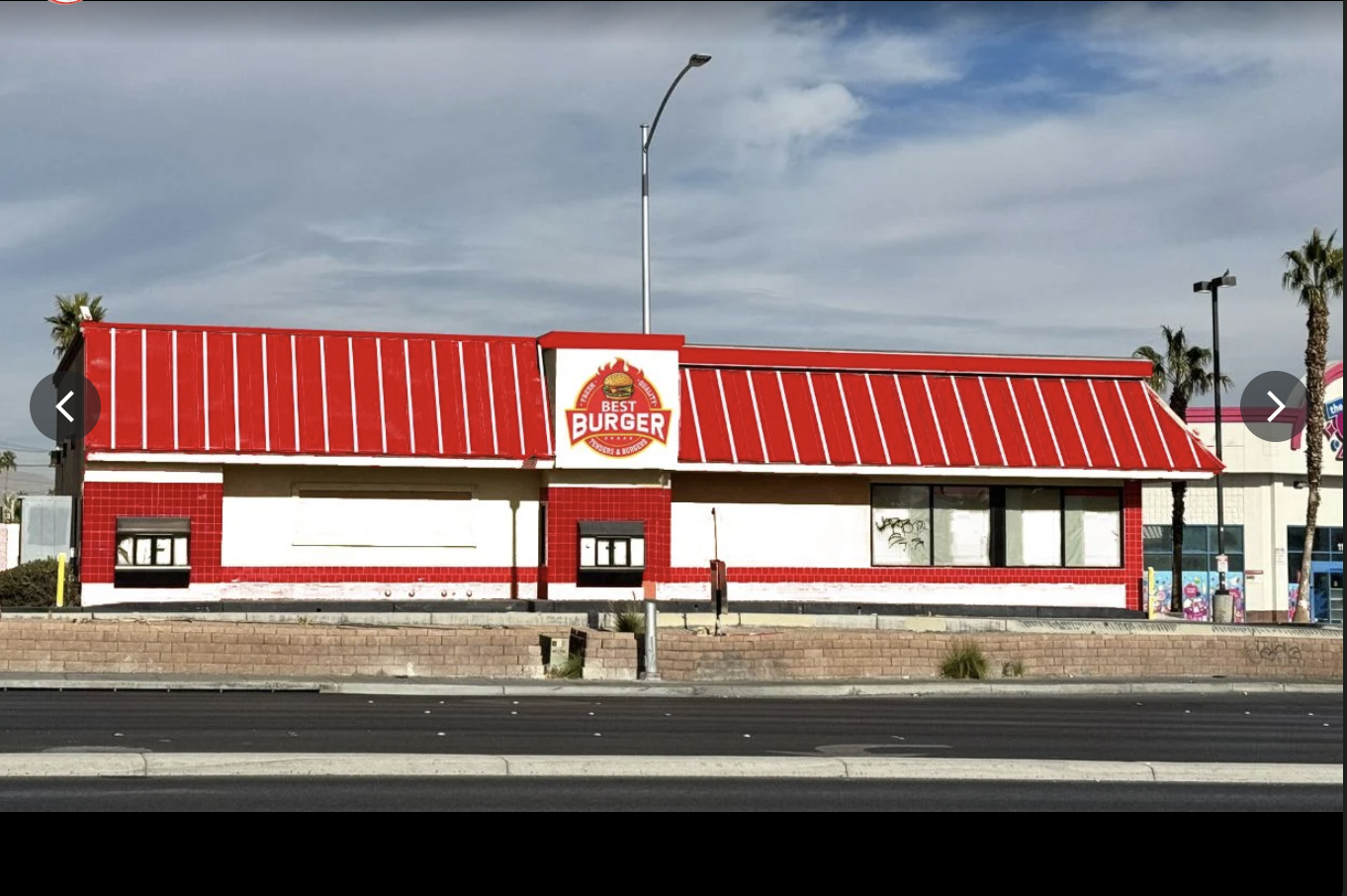 Best Burger's daytime exterior — bright red roof and white walls on a wide Las Vegas boulevard with palm trees.
